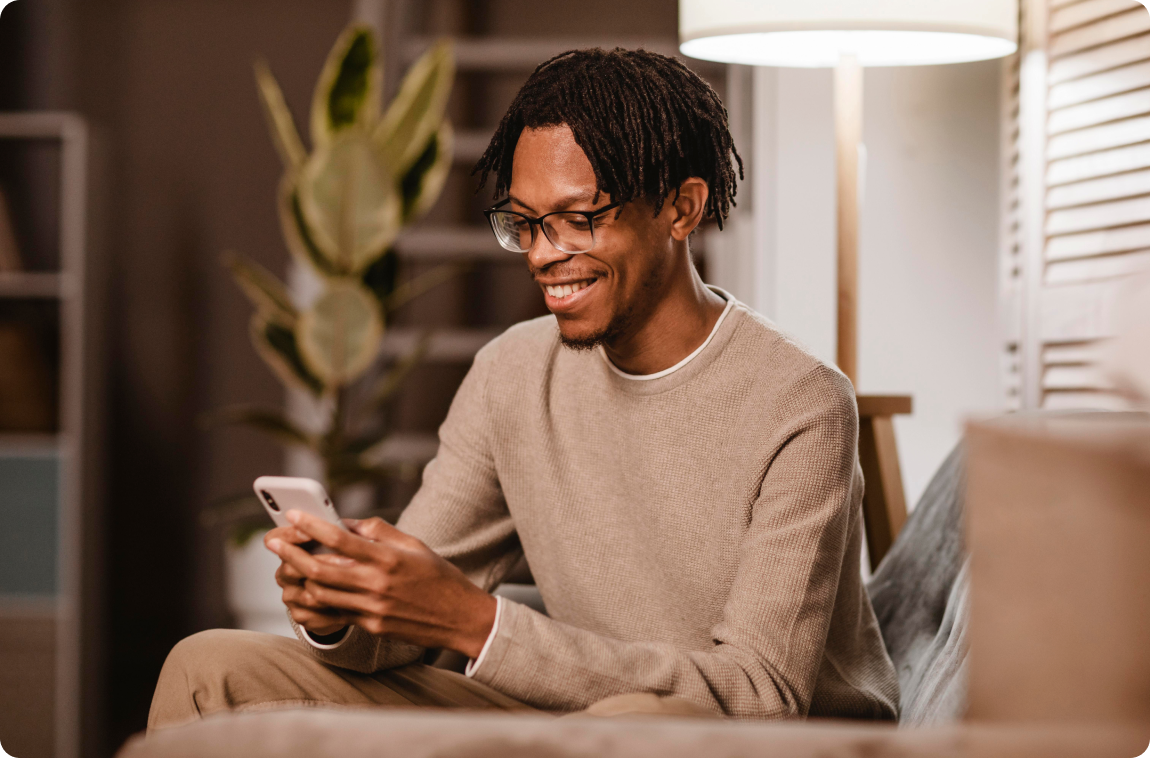 Homem sorrindo agendando atendimento pelo celular